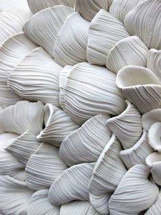 an abstract sculpture made out of white material with wavy lines on the top and bottom