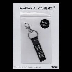 a keychain with a black tag attached to it's side in a package