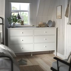 a bedroom with white furniture and wooden floors