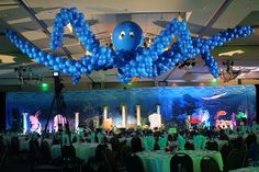 an ocean themed event with blue balloons and green tablecloths on the tables in front of them