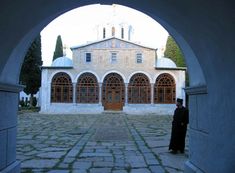 a person standing in front of a building with an arched doorway that leads into the courtyard