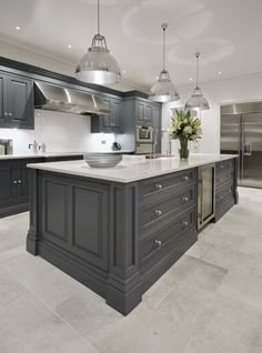 a large kitchen with gray cabinets and marble counter tops