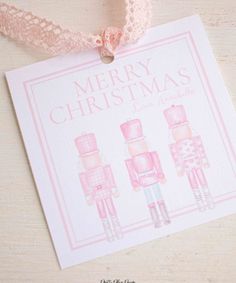 a pink christmas card with three nutcrackers on it