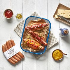 hotdogs with mustard, ketchup and relish on the side