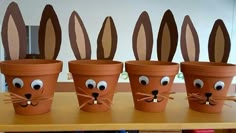 four flower pots with faces painted on them