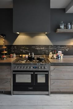 a kitchen with an oven, stove and chalkboard on the wall above it's counter