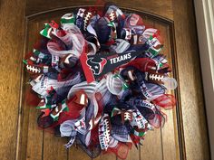 a wreath made out of mesh and footballs on the front door for a team