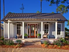 a small white house with porch and front door