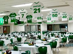 tables with green and white tablecloths are set up for a football themed party