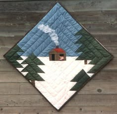 a quilted wall hanging on the side of a wooden fence