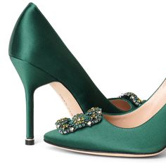 a pair of green high heeled shoes with jewel embellishments