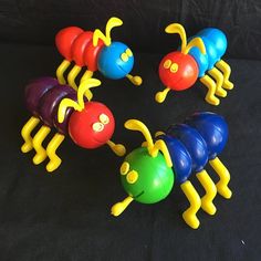 several colorful plastic caterpillars are arranged in a circle on a black background