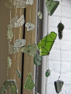 a wind chime made out of sea glass hanging from the side of a building