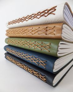 a stack of four books sitting next to each other on top of a white table