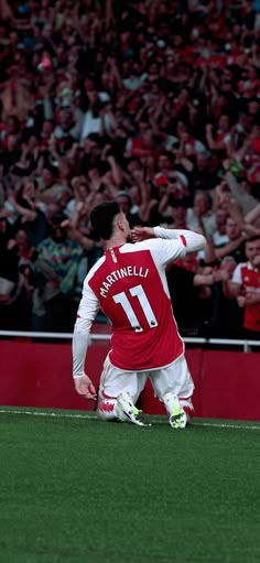 the soccer player is celebrating his team's win in front of an enormous crowd