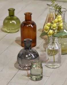 several glass vases with flowers in them sitting on the floor next to each other