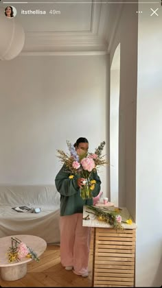 a man standing in front of a table with flowers on it