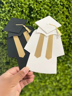 someone holding up some paper graduation decorations