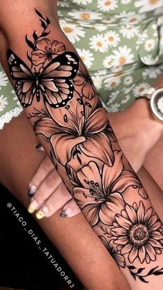 a woman's arm with flowers and butterflies on it