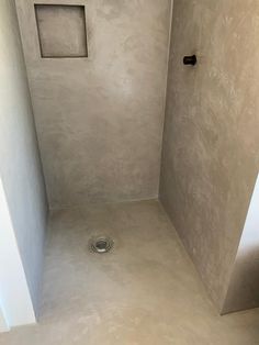 an empty bathroom with a shower head and no curtain on the wall, is seen in this image