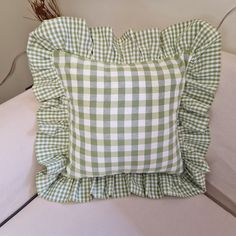 a green and white gingham pillow sitting on top of a couch