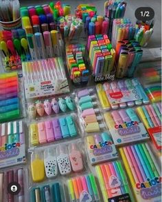 there are many different colored pens and pencils on the table