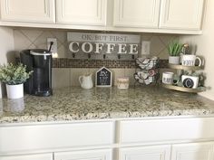 a kitchen counter with coffee cups and mugs on it