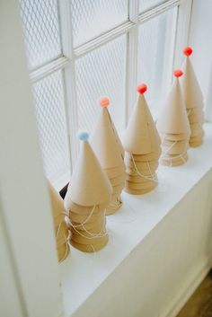 several cones are lined up on a window sill in front of a white wall