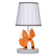 an orange and white lamp with a fox on it's face next to a gray shade