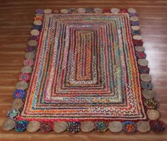 a multicolored rug is on the floor with many circles and dots around it