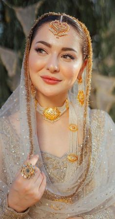 a woman wearing a veil and gold jewelry