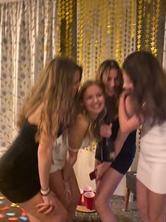 four girls are posing in front of a cake