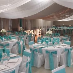 the tables are set up with blue and white linens for an elegant wedding reception