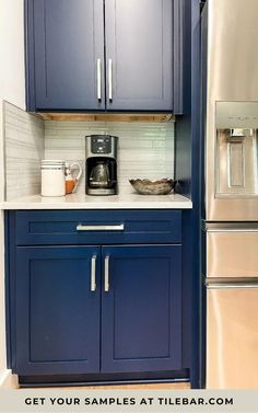 a kitchen with blue cabinets and stainless steel appliances