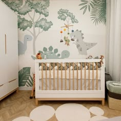 a baby's room with a dinosaur wallpaper and white crib bedding