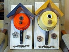 two birdhouses made out of wood with keys and knobs attached to the sides