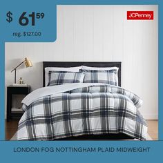 a bed with white and blue plaid comforter on it, next to a nightstand