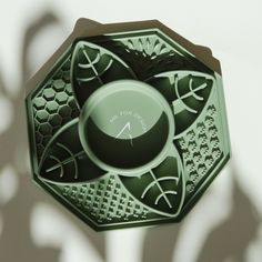 a green clock sitting on the side of a wall next to a shadow cast object