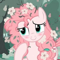 a pink pony with flowers on its head and eyes, standing in front of trees