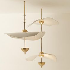 three modern ceiling lights hanging from the ceiling in a room with white walls and flooring