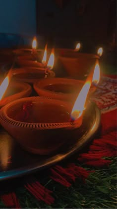 many lit candles sitting on top of a metal tray