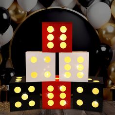 two dices are stacked on top of each other with balloons in the background