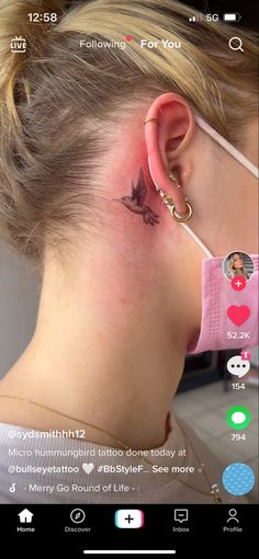 a woman with a small tattoo behind her ear