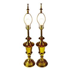 a pair of brass colored lamps sitting next to each other