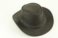 Our smooth leather cowboy hats are made of genuine cowhide leather. This beautifully handcrafted hat is made with fine craftsmanship and materials. Any scars, wrinkles or other subtle variations are characteristics of natural leather and do not affect its strength or quality. The unisex leather hat is embellished with brass conchos. The crown of the had also boasts a braided hat band. Use the strap for windy days or to keep it around your neck while traveling so you won't lose it. Perfect access Rugged Adjustable Fedora For Western-themed Events, Rugged Adjustable Hat For Rodeo, Adjustable Leather Country Fedora, Adjustable Rugged Leather Hat Bands, Country Style Leather Fedora, Rustic Leather Hat Bands For Rodeo, Country Hat With Concho And Short Brim, Country Style Concho Hat For Rodeo, Country Style Hat With Concho And Short Brim