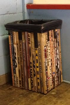 there is a trash can made out of old hockey stick's on the floor