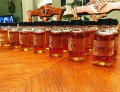 several bottles filled with liquid sitting on top of a wooden table