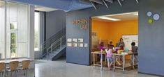 children are sitting at tables in the kitchen lab