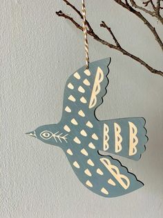 a blue bird hanging from a tree branch with the letter b on it's side