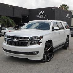 a white suv parked in front of a building